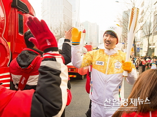 서울에서 짜릿한 희망의 불꽃을 전달한 차승원이 코카콜라 응원 스태프들과 짜릿한 코-크 하이파이브를 나누고 있다...코카콜라 제공