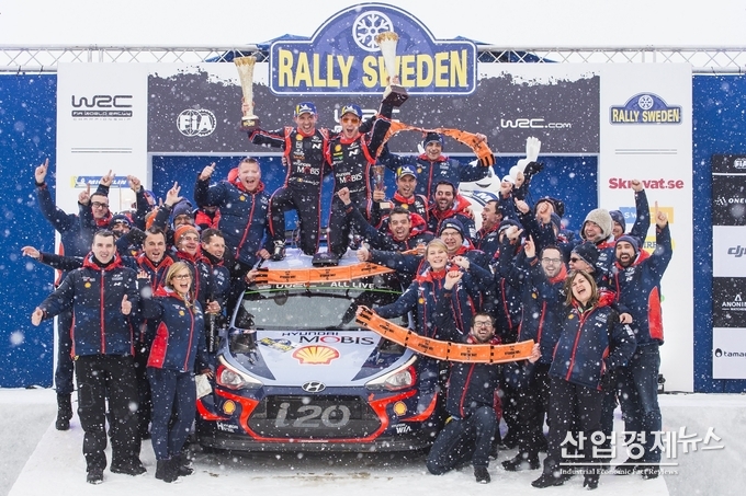 현대 랠리팀 선수와 관계자들이 신형 i20 랠리카를 둘러싸고 환호하고 있다. 사진-현대차