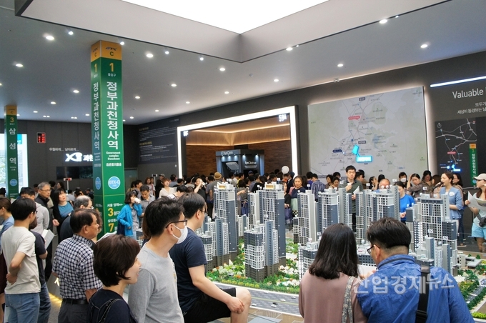 방문객들이 모형도 앞에서 분양을 검토하고 있다. 사진=GS건설