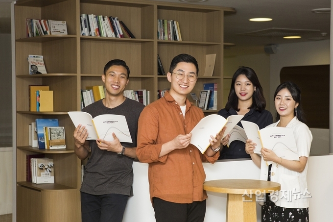 현대건설 직원들이 현대건설이 지속가능경영보고서를 보고 있다. 사진=현대건설