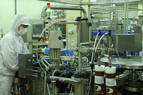 송림푸드 제조시설에서 한 직원이 설비를 통해 짜장소스를 포장용기에 주입하고 있다...<사진=송림푸드 제공>