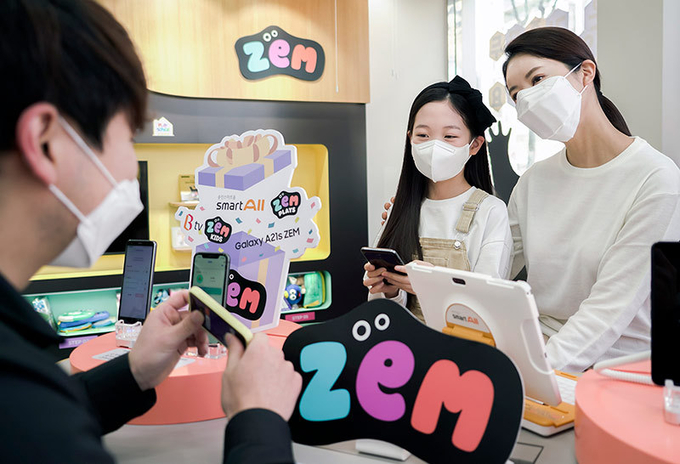 SK텔레콤은 23일부터 ZEM 서비스 고객 대상으로 새 학기 구독형 혜택을 제공하는 이벤트를 진행한다. 학부모와 자녀 고객이 SKT 매장에서 선물 혜택을 받고 즐거워 하는 모습. 사진=SKT