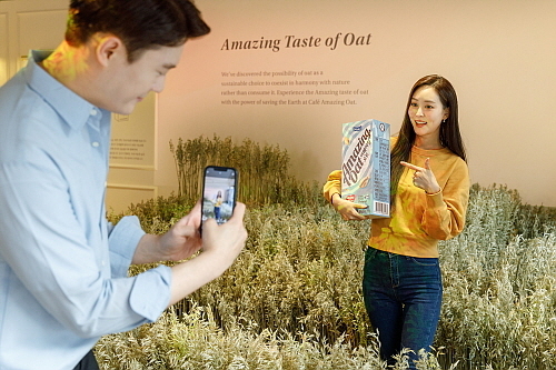 카페 내 오트밭 한 커플이 포토존에서 사진을 찍고 있는 모습<사진=매일유업 제공>