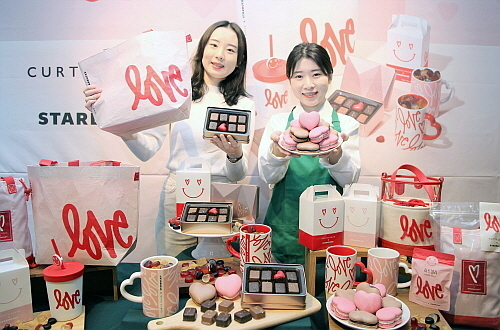 스타벅스 모델들이 커티스 쿨릭의 ‘LOVE’ 아트웍 활용한 화이트 데이 푸드와 MD를 소개하는 모습 .스타벅스 제공