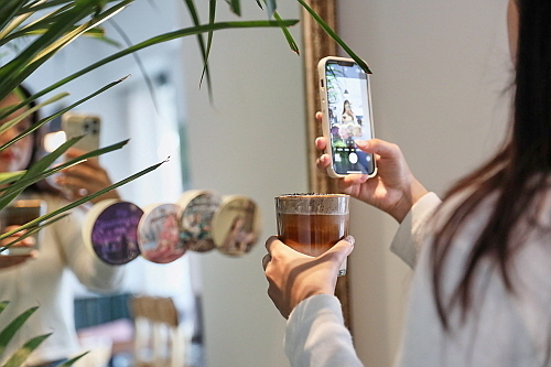 한 소비자가 서촌 카페 한 곳에서 어메이징오트 활용한 시그니처 메뉴를 들고 인증샷을 찍는 모습...<사진=매일유업 제공>