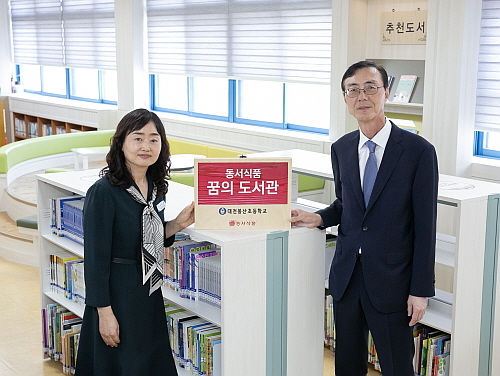 '2024 동서식품 꿈의 도서관‘ 도서 기증식에서 동서식품 최상인 홍보상무(오른쪽)와 대전봉산초 김미애 교장(왼쪽)이 현판과 함께 기념사진을 촬영하고 있다...출처:동서식품