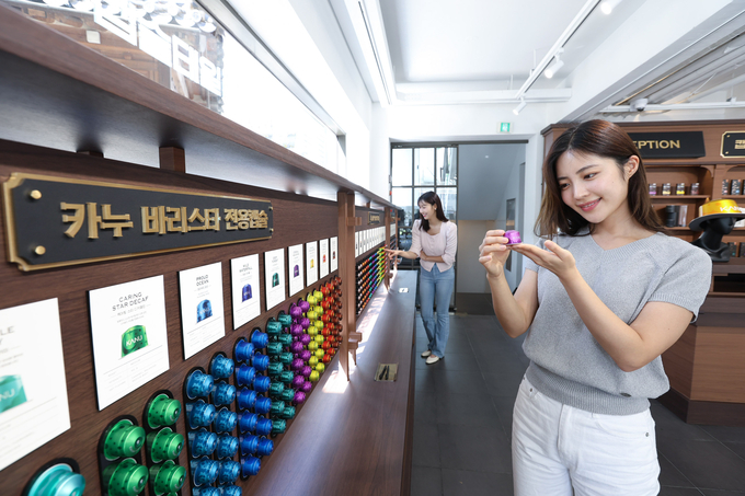 모델이 플래그십 스토어 내 캡슐 탐색 존에서 캡슐을 탐색하고 있다....<사진=동서식품 제공>
